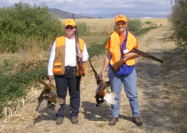 2 successful pheasant hunters show off their birds.